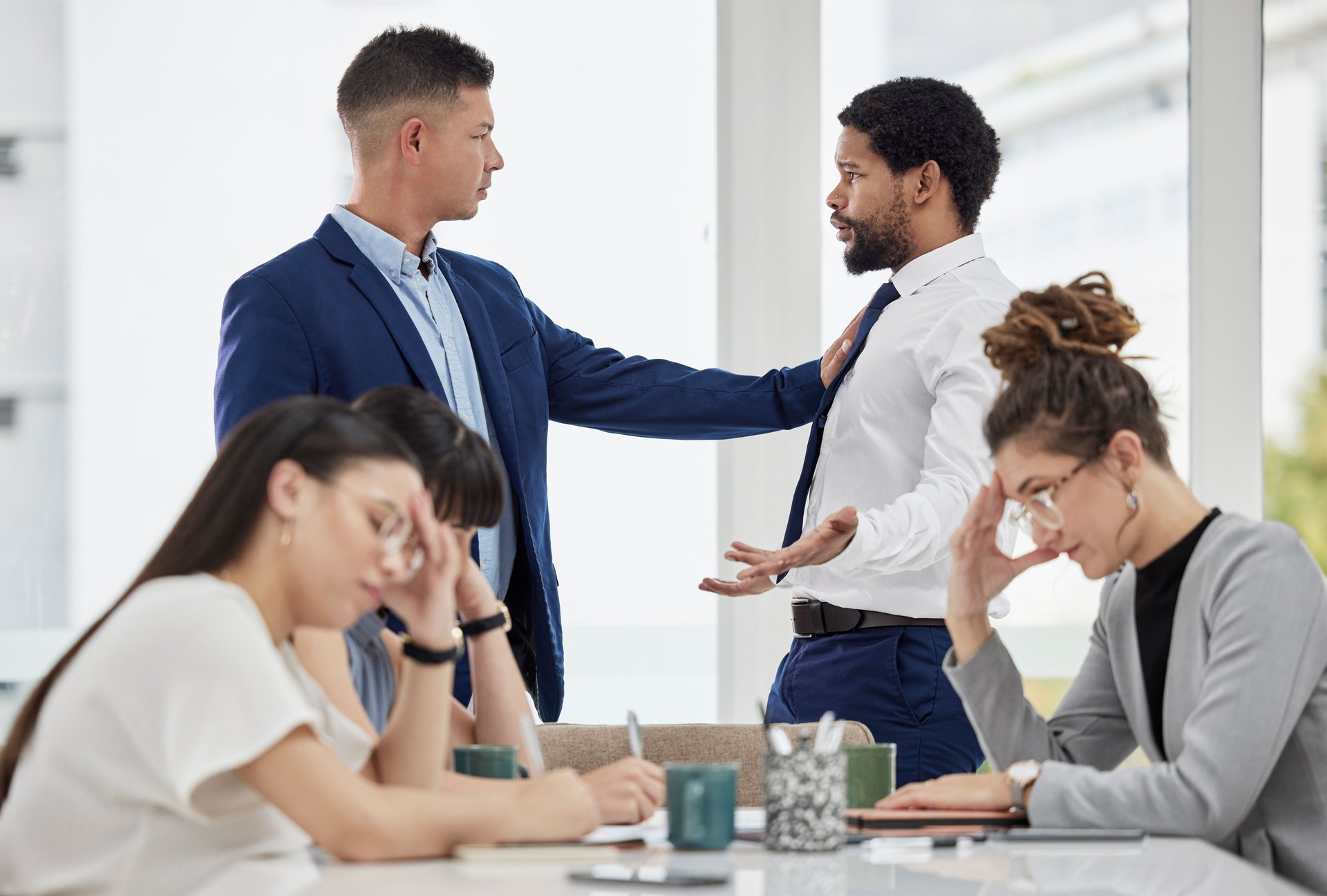 Team, frustrated and business people with conflict in office with problem, crisis and stressed out in meeting. Fight, corporate and men and women in serious discussion for mistake, risk and warning